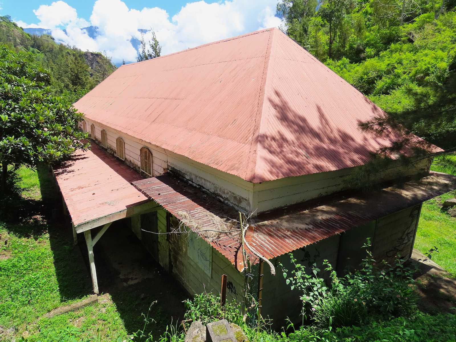 Les anciens thermes de Cilaos, bâtiment à toit rouge au bord du Bras des Étangs