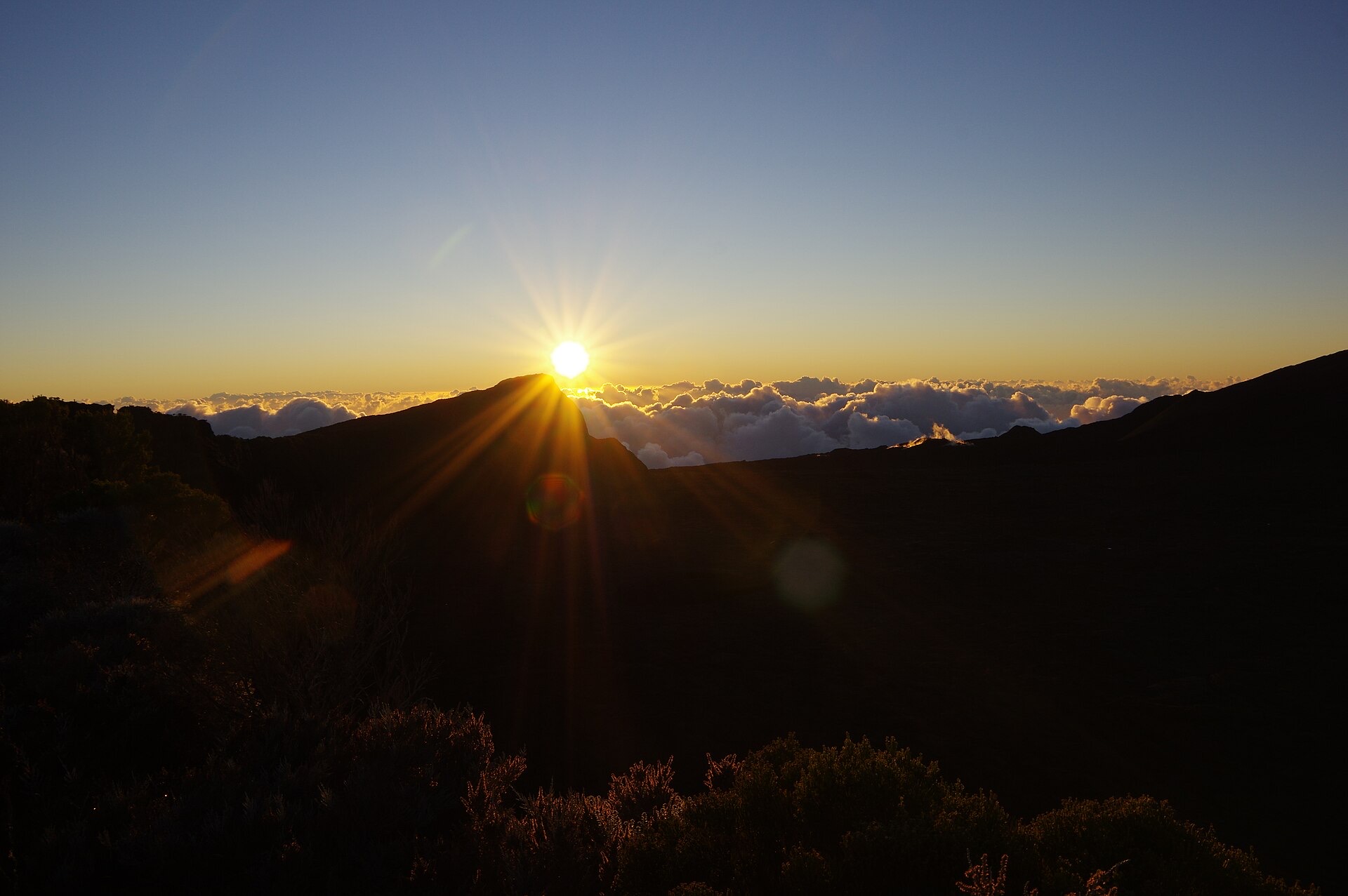 Lever de soleil sur le massif du Piton de la Fournaise, le disque solaire juste au-dessus de la crête